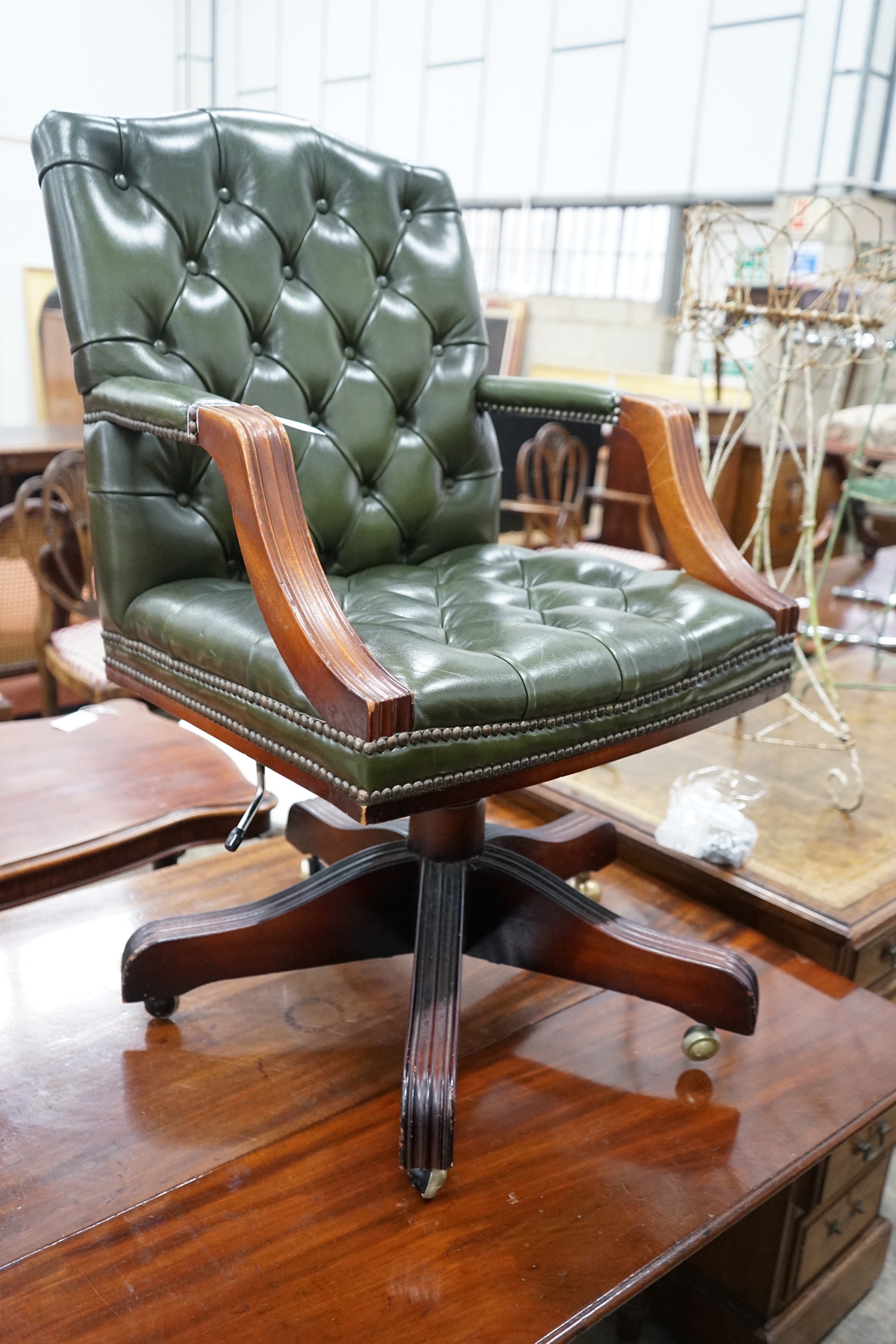 A reproduction mahogany and buttoned green leather swivel desk chair, width 56cm, depth 51cm, height 94cm